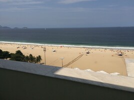 Uma praia com guarda-sóis e pessoas.