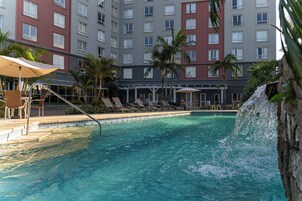 Una piscina al aire libre, sillones reclinables de piscina