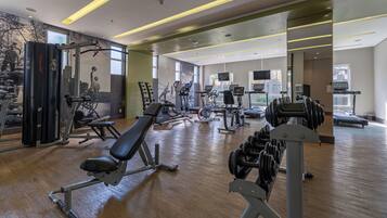 Uma academia com diversos equipamentos de exercício, incluindo esteiras, bicicletas ergométricas e aparelhos de musculação.