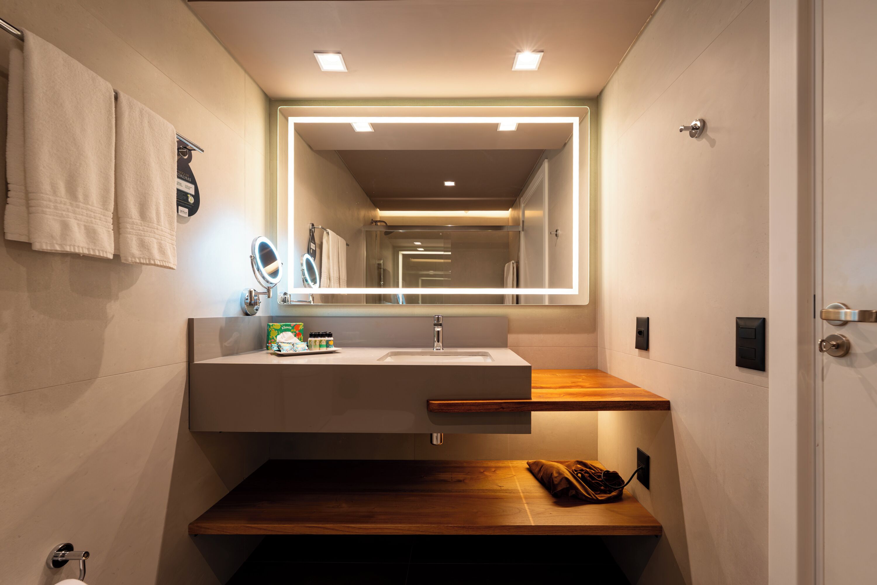 A modern bathroom with a built-in sink, a mirror, and a wooden countertop.