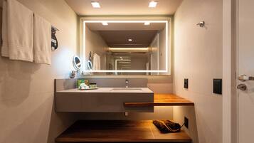 A modern bathroom with a built-in sink, a mirror, and a wooden countertop.