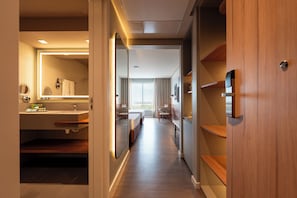 Una habitación de hotel con baño, pasillo y cama.