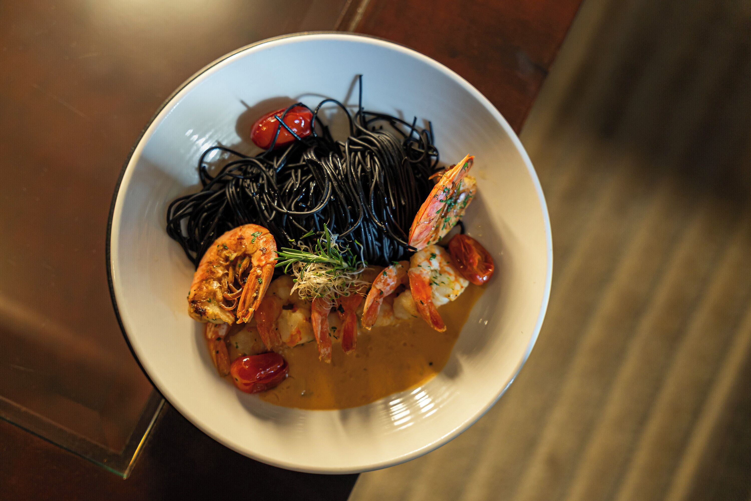 A bowl of food with seafood and noodles.