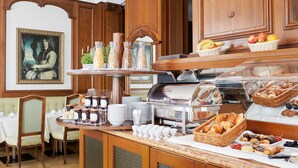 Montaje tipo buffet con diversas opciones de comida, como frutas, pasteles y salsas.