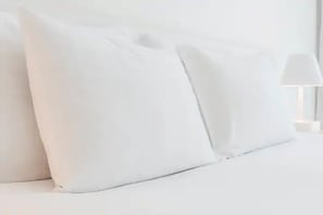 Un lit avec une literie et des oreillers blancs.