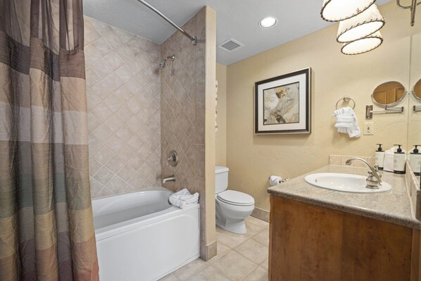A bathroom with a bathtub, toilet, sink, and shower.