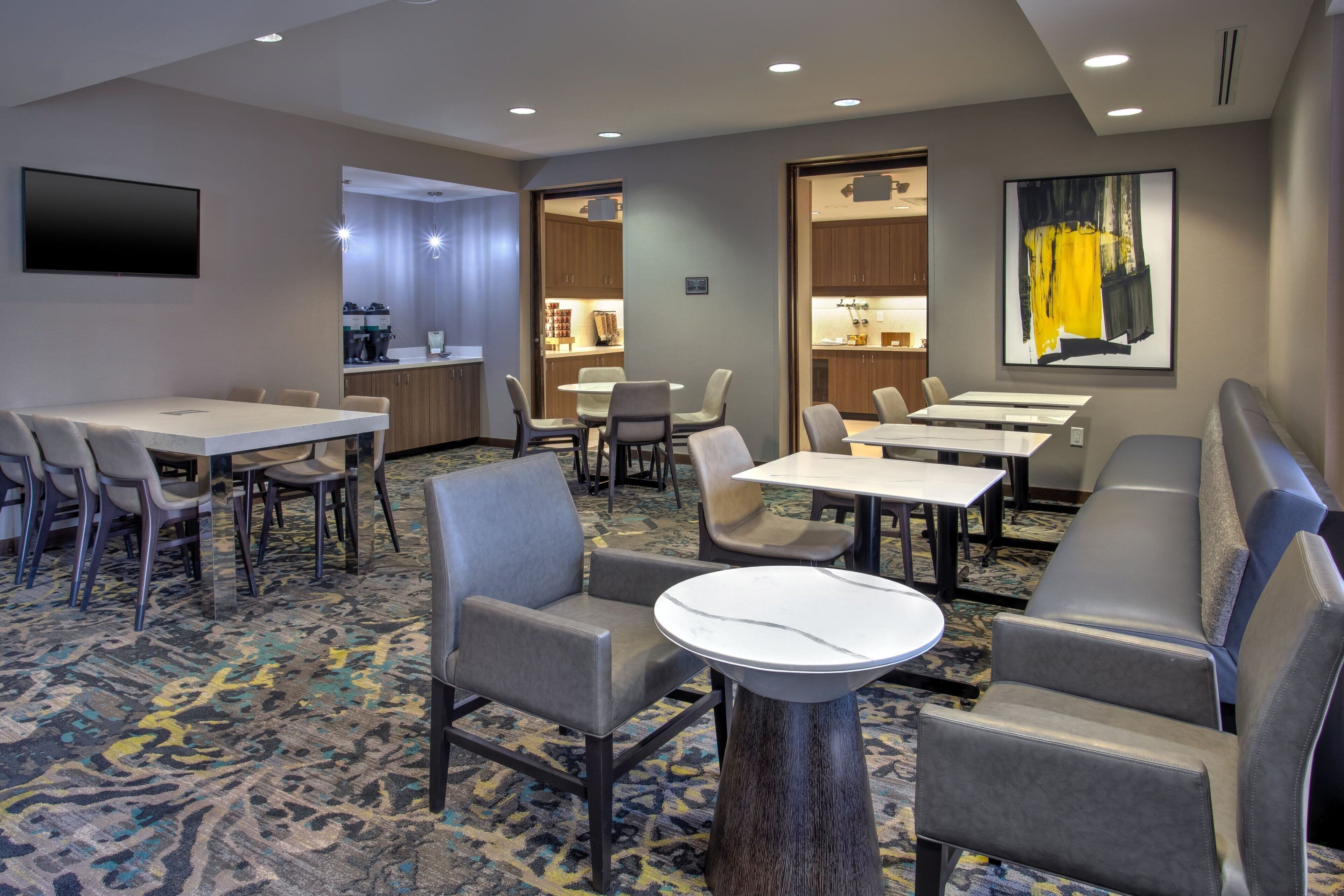 A hotel room with a dining area, a kitchen, and a living area.