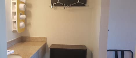 A bathroom with a sink, towel rack, and a black storage unit.