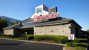 A building with a sign reading "Crimson Cup Coffee Drive Thru" and a sign indicating a coffee drive-thru service. - Olentangy Motor Inn (Columbus)