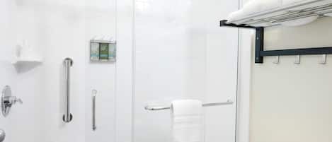 A modern bathroom with a glass-enclosed shower, a toilet, and a towel rack.