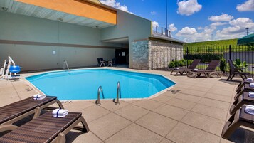 Una piscina al aire libre de temporada, sillones reclinables de piscina