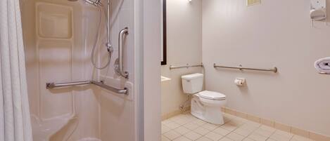 A bathroom with a shower, toilet, and grab bars.