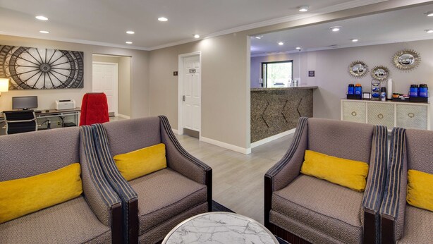 A hotel lobby with two sofas, a reception desk, and a large decorative mirror. - Best Western Clermont (Cincinnati)