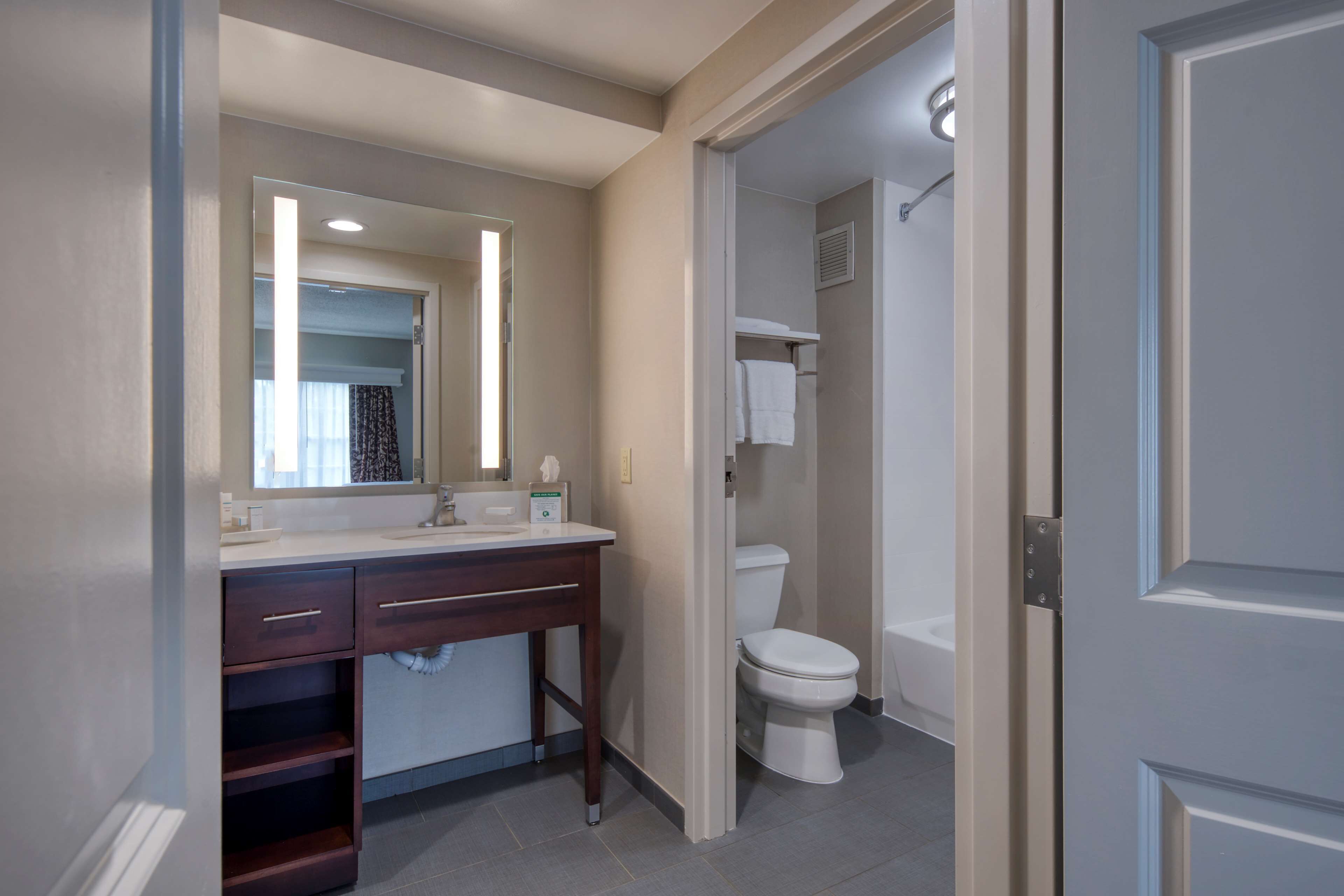 Une salle de bain moderne avec un meuble-lavabo, un évier, un miroir et des toilettes.