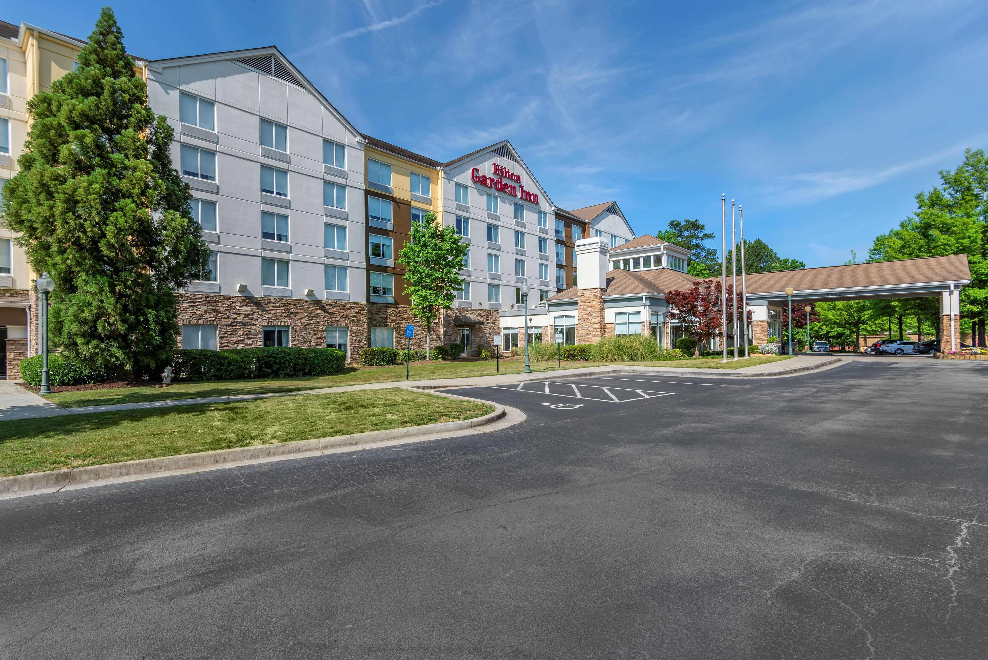A hotel with a modern design, featuring a prominent sign for Hilton Garden Inn.