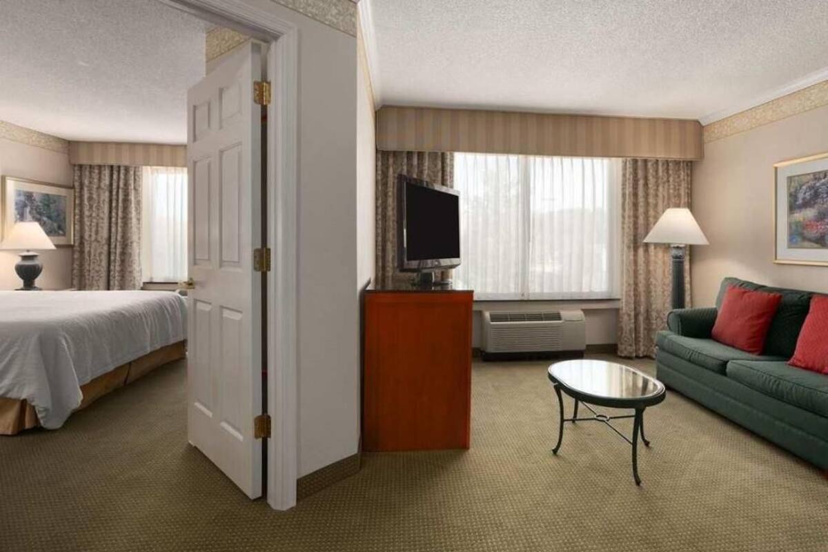 Une chambre d’hôtel équipée d’un lit, d’une télévision, d’un canapé, d’une table basse et d’un bureau.