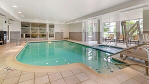 A large indoor swimming pool with clear water, surrounded by a tiled floor and walls. - Hilton Garden Inn Portland Airport (Portland)