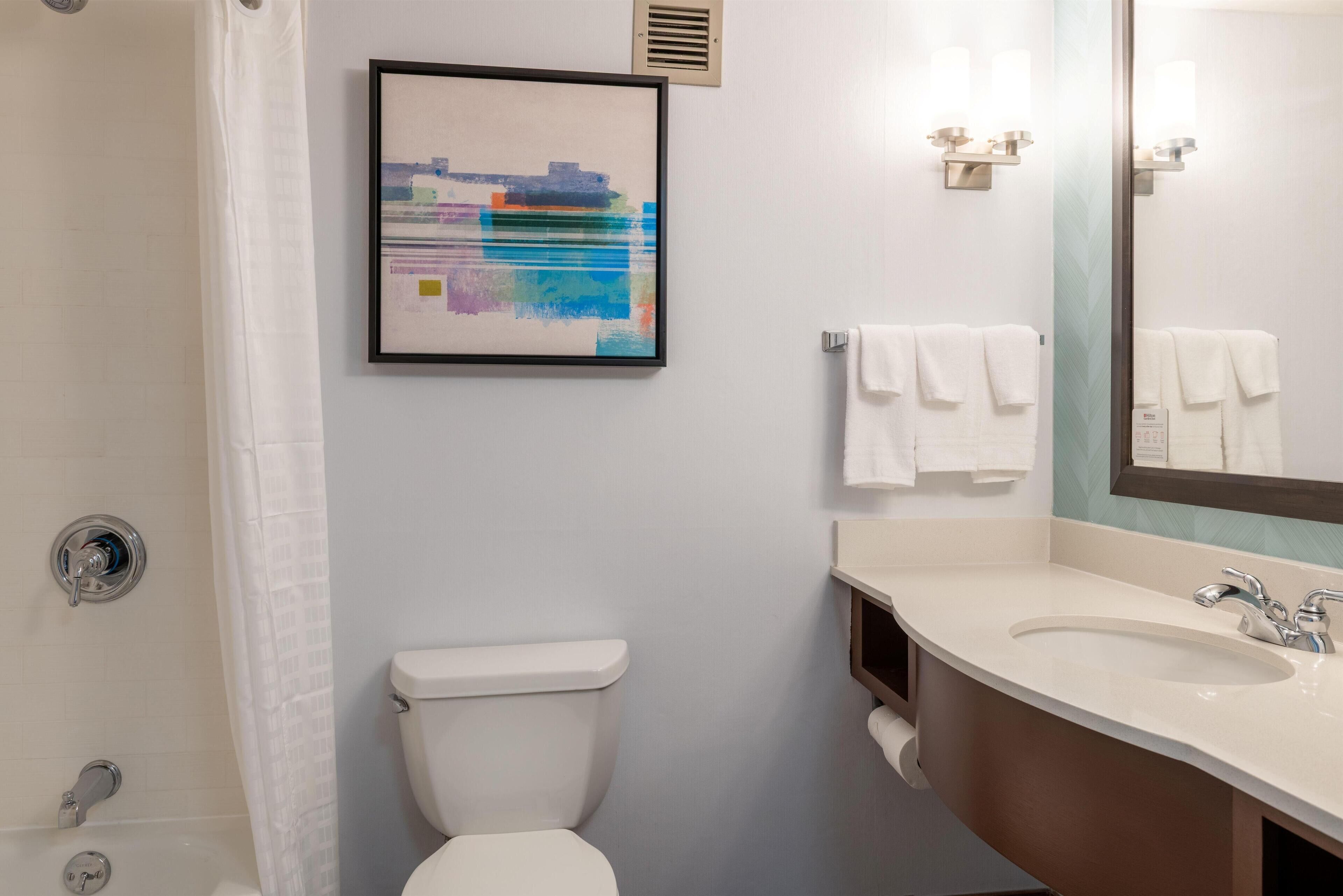 A modern bathroom with a toilet, sink, and shower.