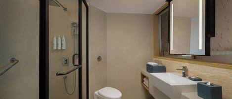 A modern bathroom with a shower, toilet, and sink.