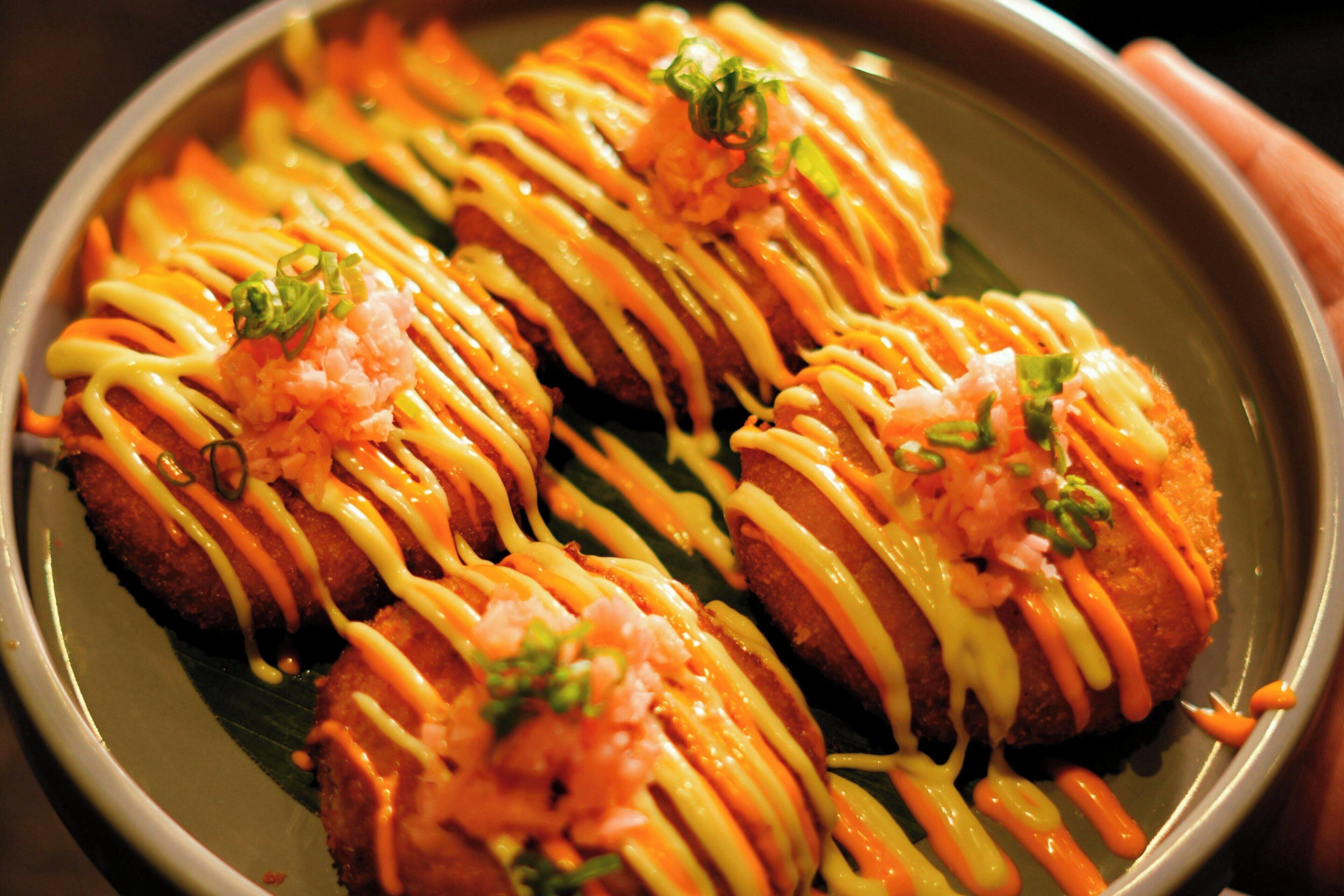 A plate of food with a garnish of green onions and a drizzle of sauce.