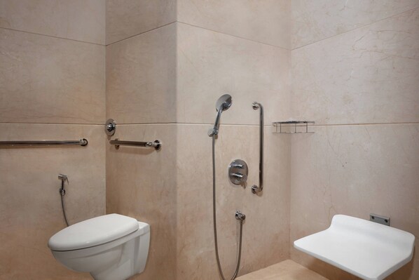 A bathroom with a toilet, a shower, and a sink.