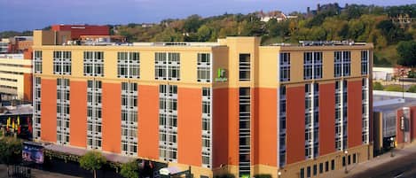Un hotel Holiday Inn de varios pisos con fachada plana, amplias ventanas y un estacionamiento al frente.