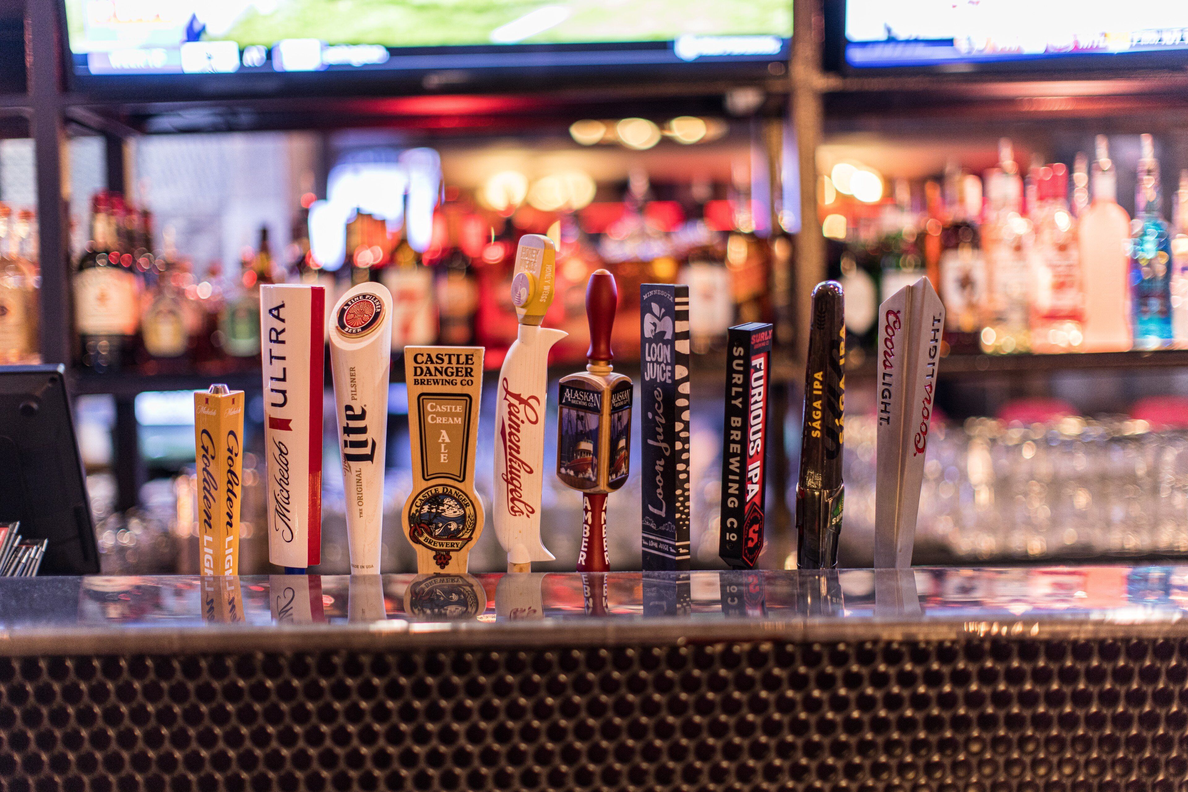 A bar with various beer taps and bottles.