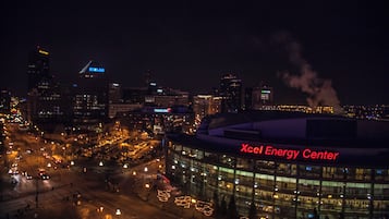 A nighttime cityscape with illuminated buildings and a prominent Xcel Energy Center.