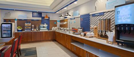 A modern breakfast area with a self-serve station, seating, and a water dispenser.