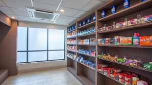 Un supermercado con estantes llenos de productos y un amplio ventanal que proporciona luz natural.