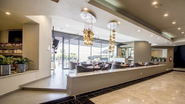 A modern hotel lobby with a reception desk, seating area, and a large chandelier. - Hotel Misión Toreo Centro De Convenciones (Naucalpan)