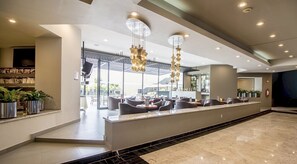 A modern hotel lobby with a reception desk, seating area, and a large chandelier. - Hotel Misión Toreo Centro De Convenciones (Naucalpan)