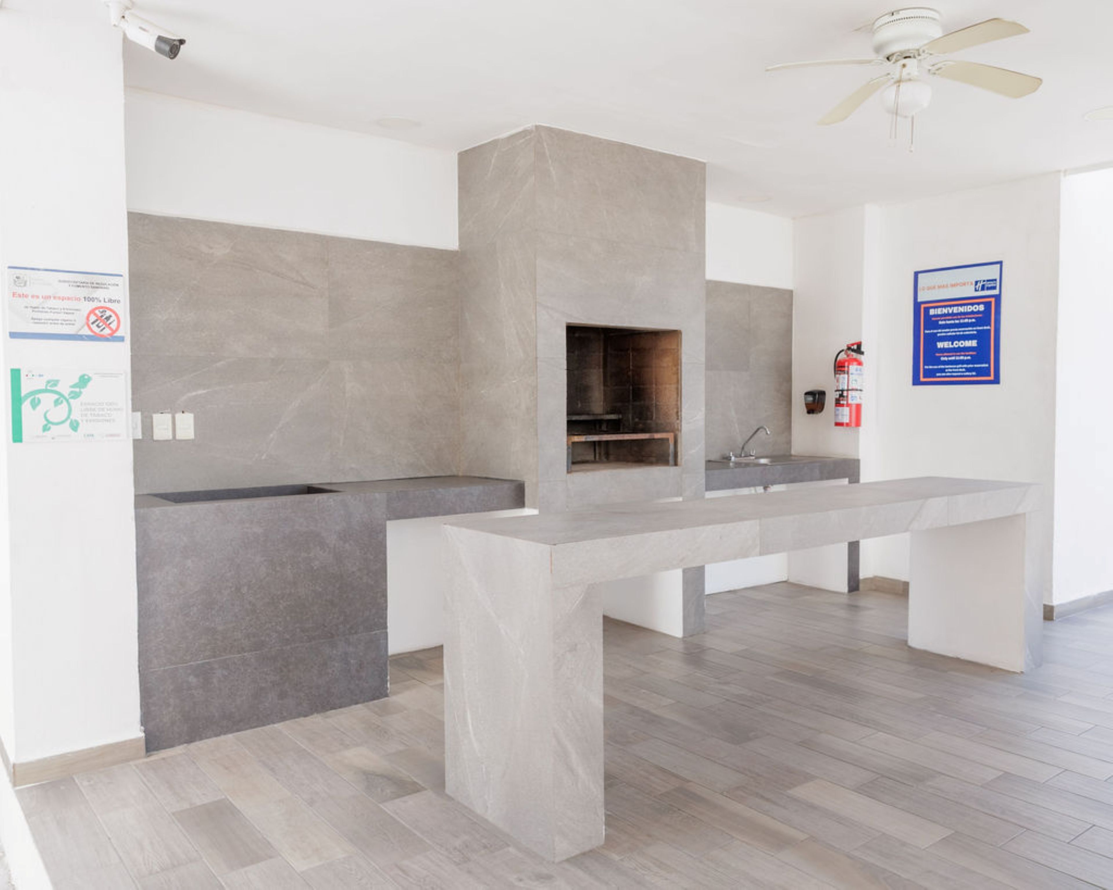A modern kitchen with a built-in stove, a sink, and a ceiling fan.
