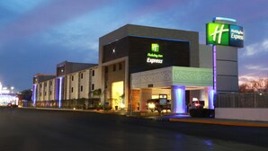 Un bâtiment de l’hôtel Holiday Inn Express, avec une enseigne bien visible, une entrée abritée et un espace de stationnement.