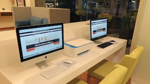 Un comptoir d’accueil équipé de deux écrans, d’une imprimante et d’un clavier.