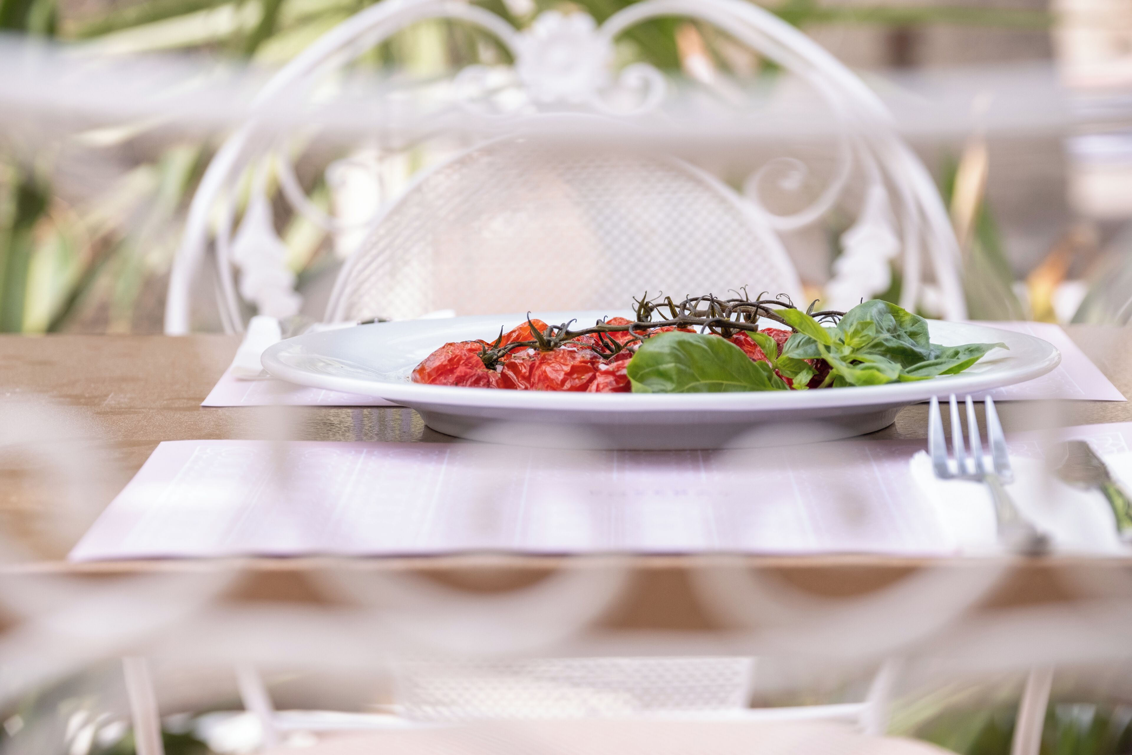 Une table à manger avec une assiette de nourriture, une fourchette et une chaise.