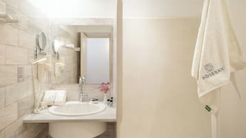 A bathroom with a sink, mirror, towel rack, and a visible door leading to another room.