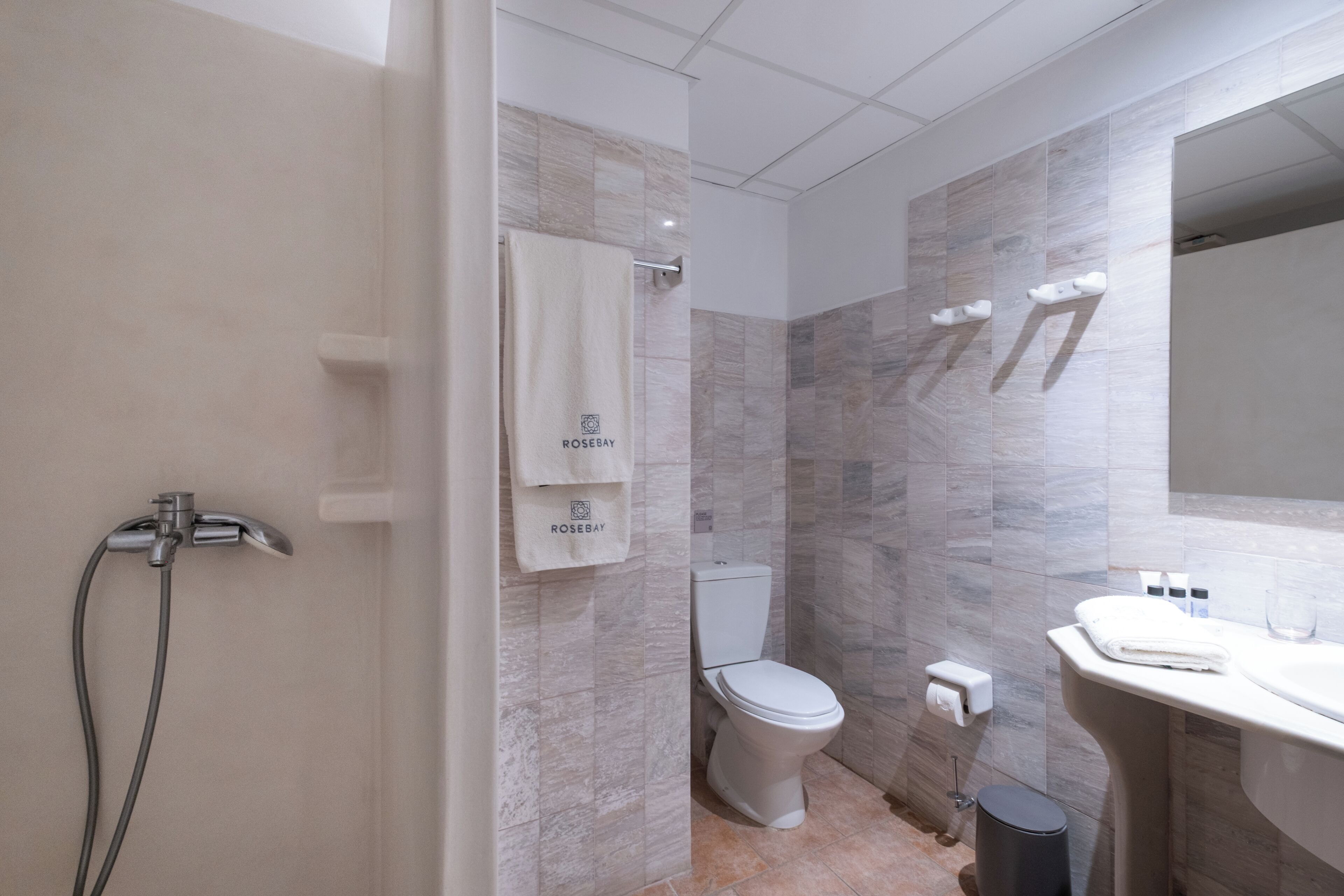 A modern bathroom with a shower, toilet, and sink.