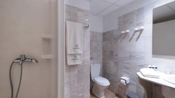 A modern bathroom with a shower, toilet, and sink.