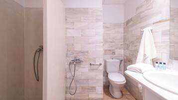 A bathroom with a shower, toilet, and bathtub.