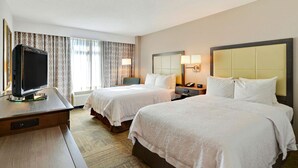 A hotel room with two beds, a desk with a television, and a window with curtains. - Hampton Inn Alexandria-Old Town/King St. Metro (Alexandria)