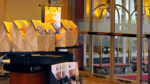 A lobby area with a reception desk, a chandelier, a large lamp, and a glass door leading outside. - Hampton Inn Alexandria-Old Town/King St. Metro (Alexandria)
