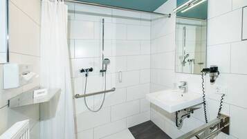 Un baño moderno con ducha, lavamanos y retrete.