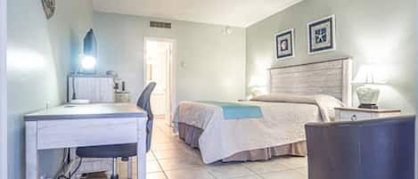 Un dormitorio con cama, escritorio y silla.