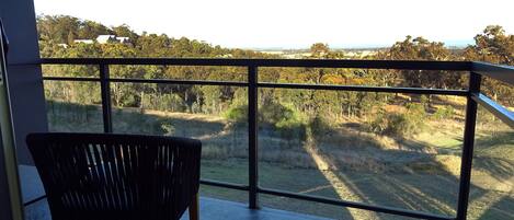Un balcon offrant une vue sur un paysage rural, avec des arbres et des champs à perte de vue.