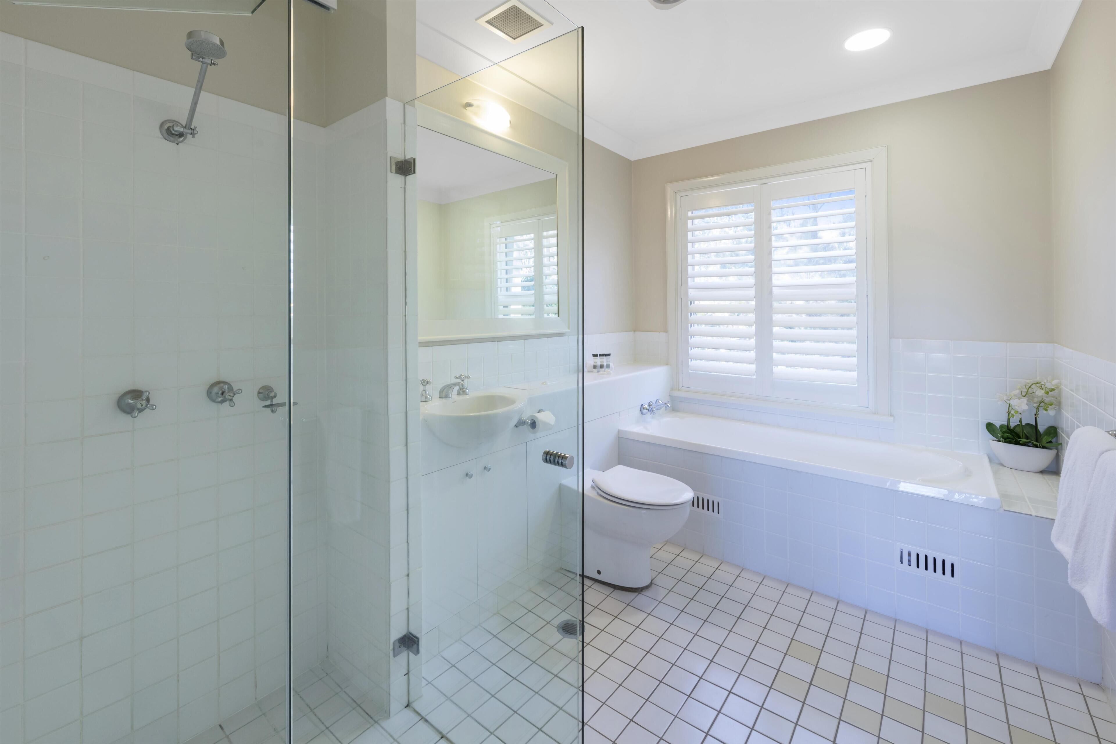 A modern bathroom with a glass shower enclosure, a white sink, a toilet, and a bathtub.