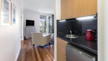 A modern kitchen with a built-in dishwasher, a red coffee maker, and a large window offering a view of the outdoors.