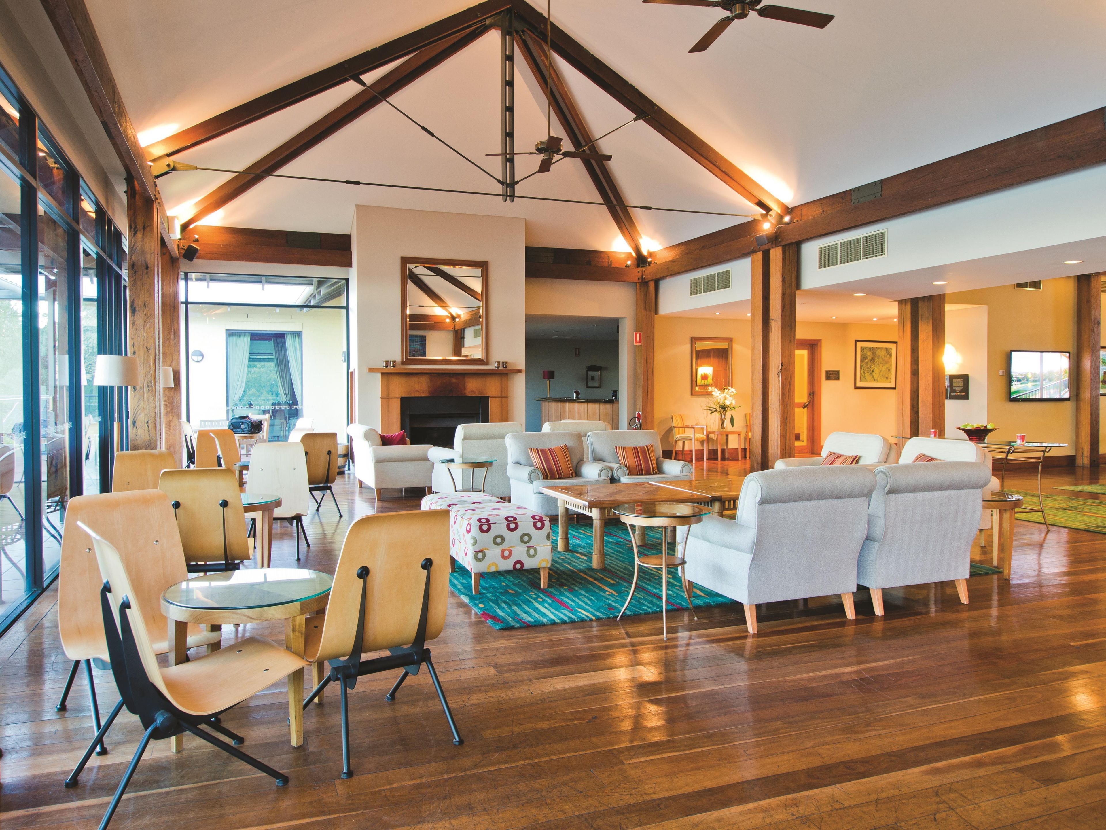 A spacious living area with wooden beams, a fireplace, and modern furniture.