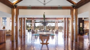 A spacious lobby with high ceilings, wooden beams, and a central round table. - Oaks Cypress Lakes Resort (Pokolbin)