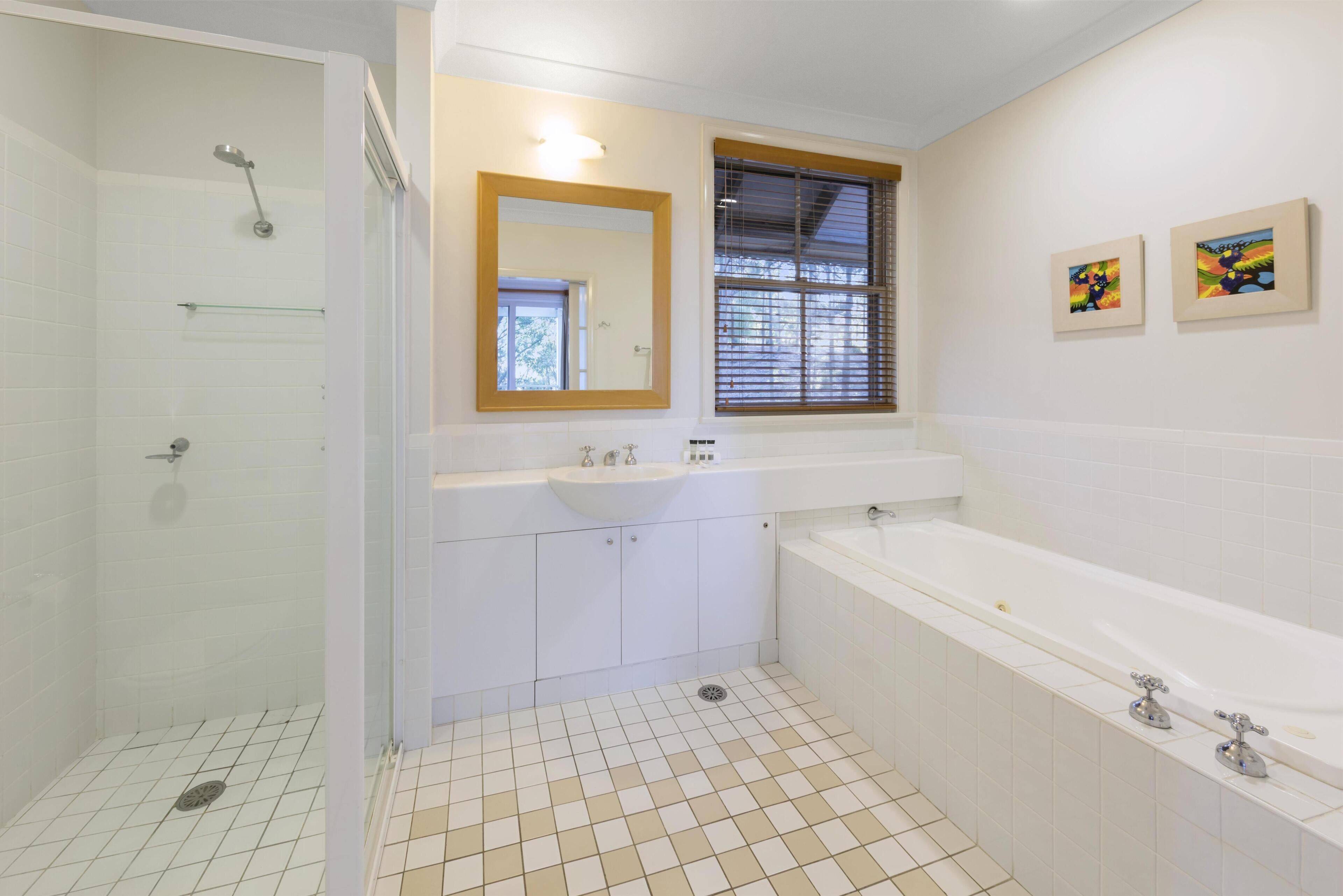 Un baño moderno con ducha, lavabo y bañera.